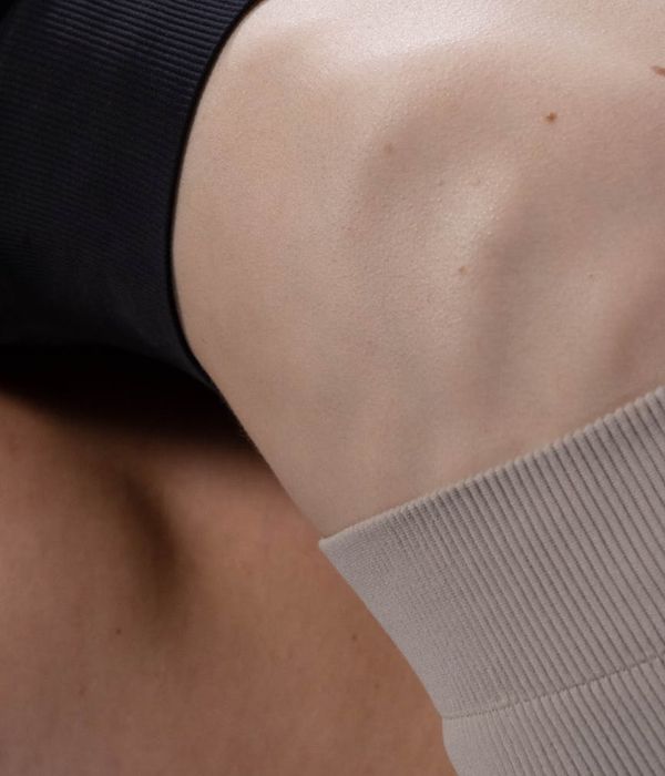 Person performing a fluid stretching movement in a minimalist room.